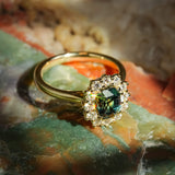 Green sapphire and diamond cluster engagement ring with oval gemstone