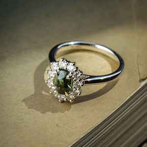 Green sapphire engagement ring with oval gemstone and diamond cluster halo