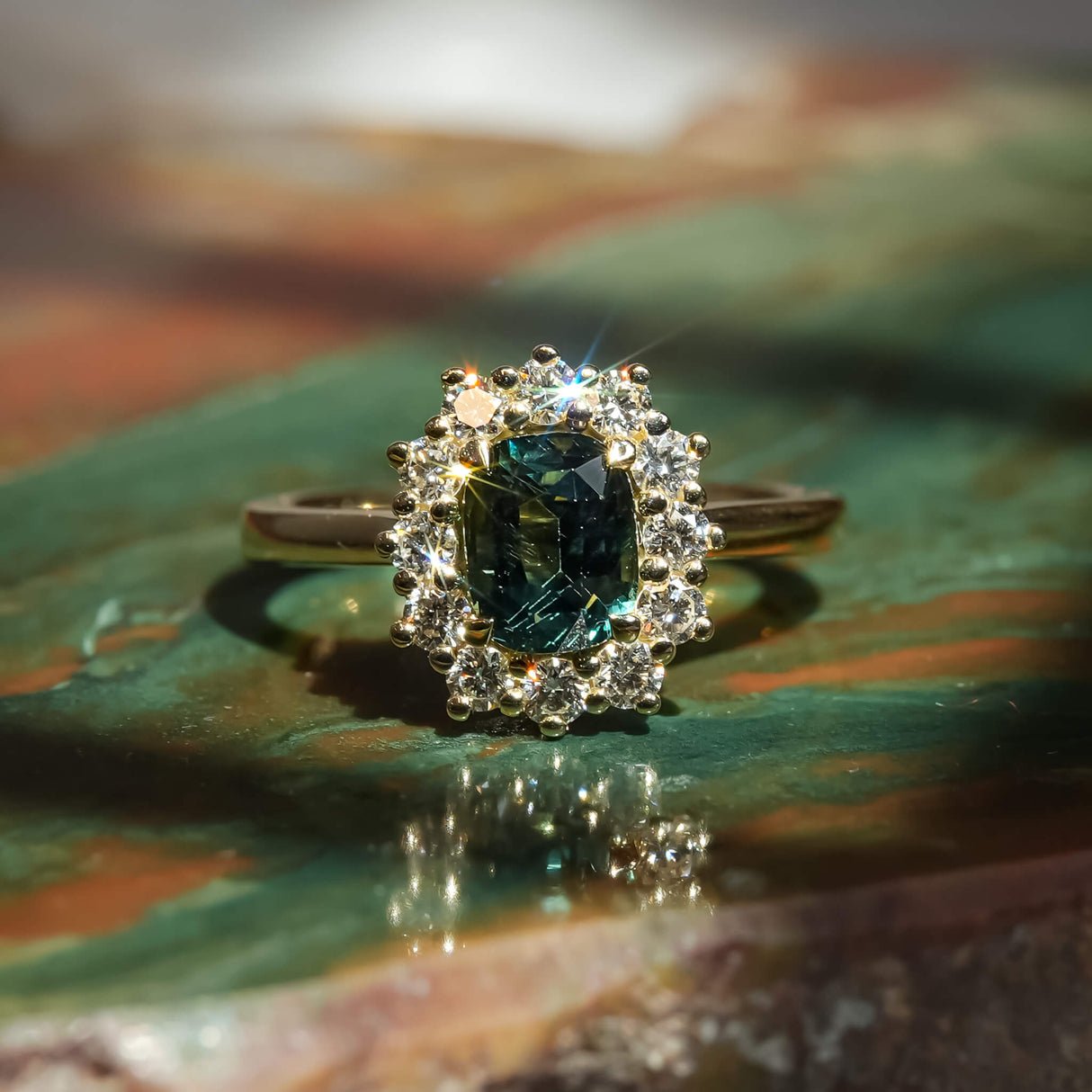 Oval green sapphire surrounded by diamond cluster engagement ring