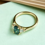 Green sapphire and diamond three stone engagement ring with yellow gold band