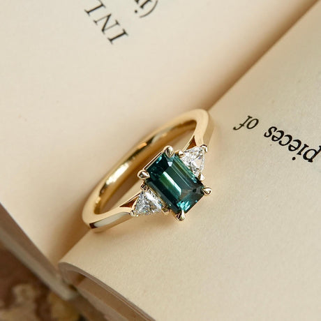 Classic green sapphire and diamond three stone engagement ring in yellow gold