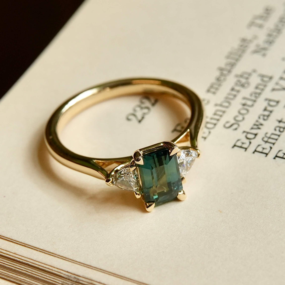 Green sapphire and diamond three stone engagement ring in yellow gold