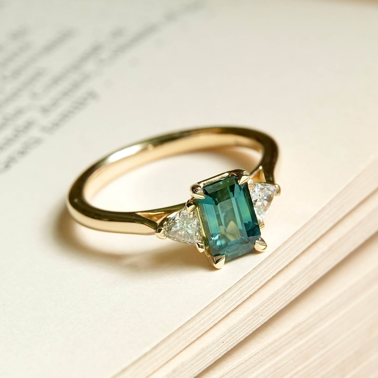 Green sapphire center stone with diamond side stones engagement ring in yellow gold