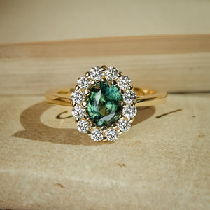 Oval green sapphire halo diamond engagement ring in yellow gold