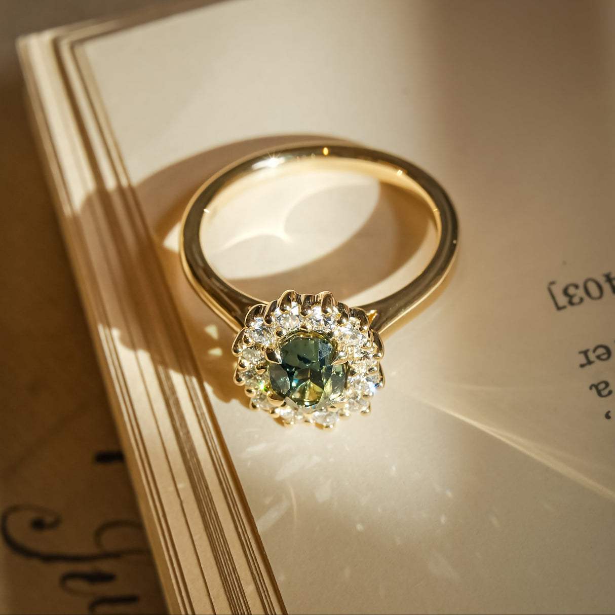 Green sapphire engagement ring with oval gemstone and diamond halo cluster