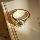 Green sapphire engagement ring with oval gemstone and diamond halo cluster