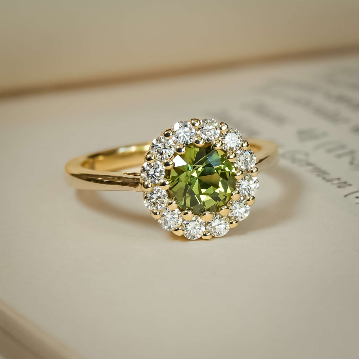 Round green sapphire engagement ring with diamond halo cluster setting