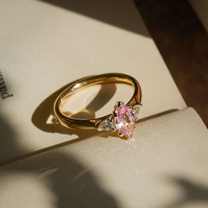 Marquise cut padparadscha sapphire and diamond three stone engagement ring in yellow gold setting