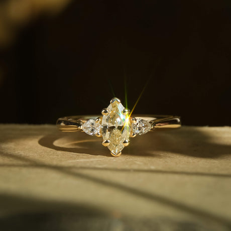 Marquise diamond three stone engagement ring with diamond side stones in yellow gold