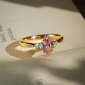 Marquise padparadscha pink sapphire and diamond three stone engagement ring in classic yellow gold setting