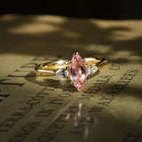 marquise pink sapphire three stone engagement ring with diamond side stones in yellow gold