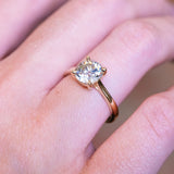 Cushion old-mine cut diamond solitaire engagement ring with gold band and raised solitaire setting.