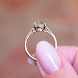 Cushion old-mine cut diamond solitaire engagement ring showing open gallery setting and gold band.