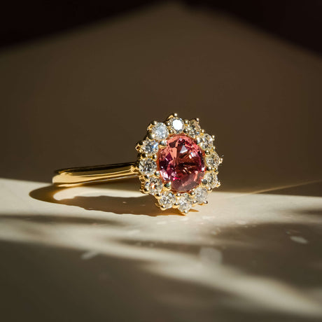 orange sapphire diamond cluster ring with halo setting in yellow gold