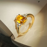 Orange cushion cut sapphire ring with diamond trefoil cluster on gold band