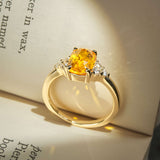 Orange sapphire ring with cushion cut gemstone and diamond trefoil cluster design