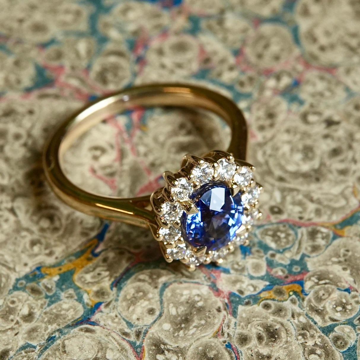 Oval-cut blue sapphire and diamond cluster engagement ring