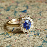 Oval-cut blue sapphire and diamond cluster engagement ring