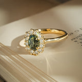 Oval green sapphire ring with diamond cluster halo setting