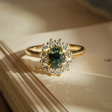 Oval green sapphire engagement ring with diamond cluster halo setting