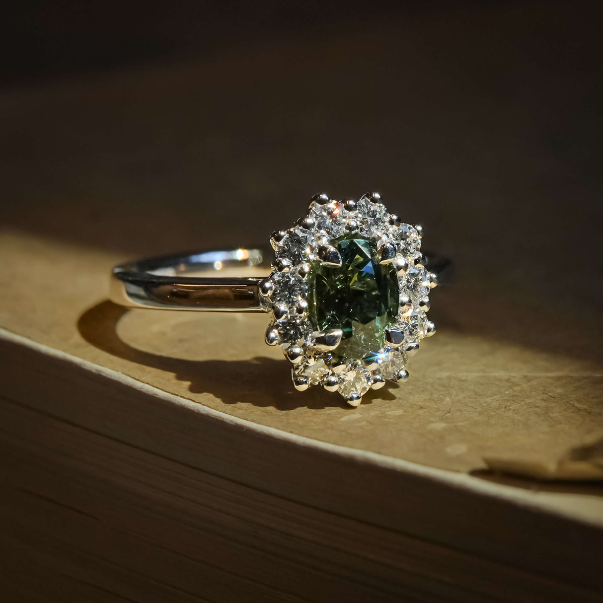 Oval green sapphire engagement ring with diamond cluster halo setting