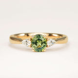 Oval Sri Lankan green sapphire and diamond three-stone wed-fit engagement ring in yellow gold.