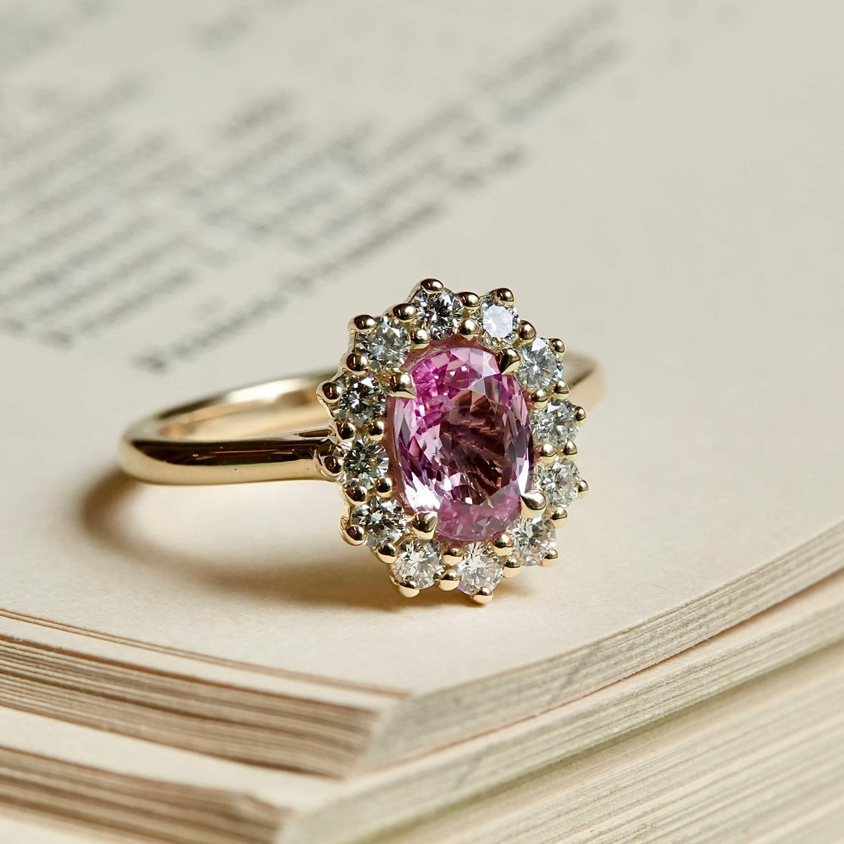 Padparadscha pink sapphire engagement ring with diamond halo cluster