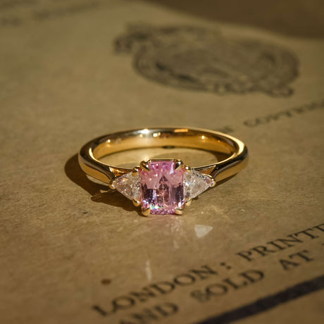 Padparadscha sapphire center stone with trillion diamonds three stone engagement ring