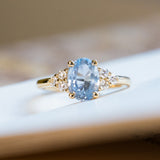 Pale blue sapphire and diamond cluster tre-foil engagement ring with oval sapphire and diamond-set shoulders.