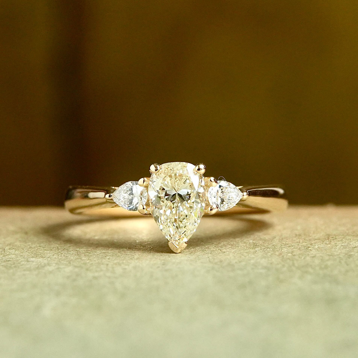 Pear cut diamond engagement ring with side diamonds in yellow gold