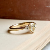 Pear cut diamond three stone engagement ring in yellow gold