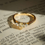 pear cut yellow diamond three stone engagement ring with white diamond side stones in yellow gold