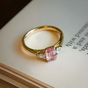 Pink sapphire and diamond three stone engagement ring with classic yellow gold setting