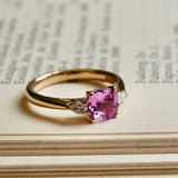 Pink sapphire and diamond three stone engagement ring in yellow gold