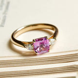 Pink sapphire center stone with diamond side stones engagement ring in yellow gold