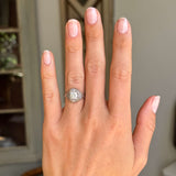 Antique diamond cluster engagement ring from the Art Deco period on a hand