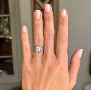 Antique diamond cluster engagement ring from the Art Deco period on a hand