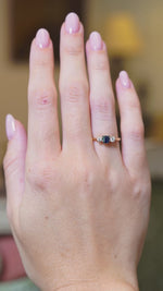 Antique 1920s sapphire and diamond three-stone ring worn on hand in motion.