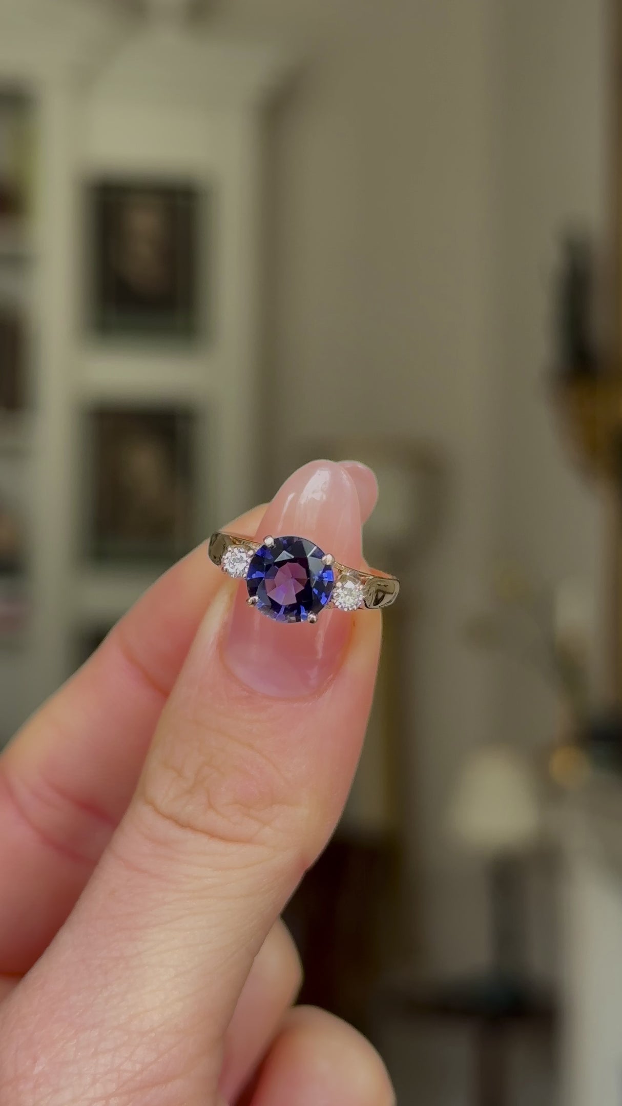 Vintage Iolite and Diamond Three-Stone Engagement Ring, 18ct Yellow Gold held in fingers and rotated to give perspective.