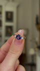 Vintage Iolite and Diamond Three-Stone Engagement Ring, 18ct Yellow Gold held in fingers and rotated to give perspective.