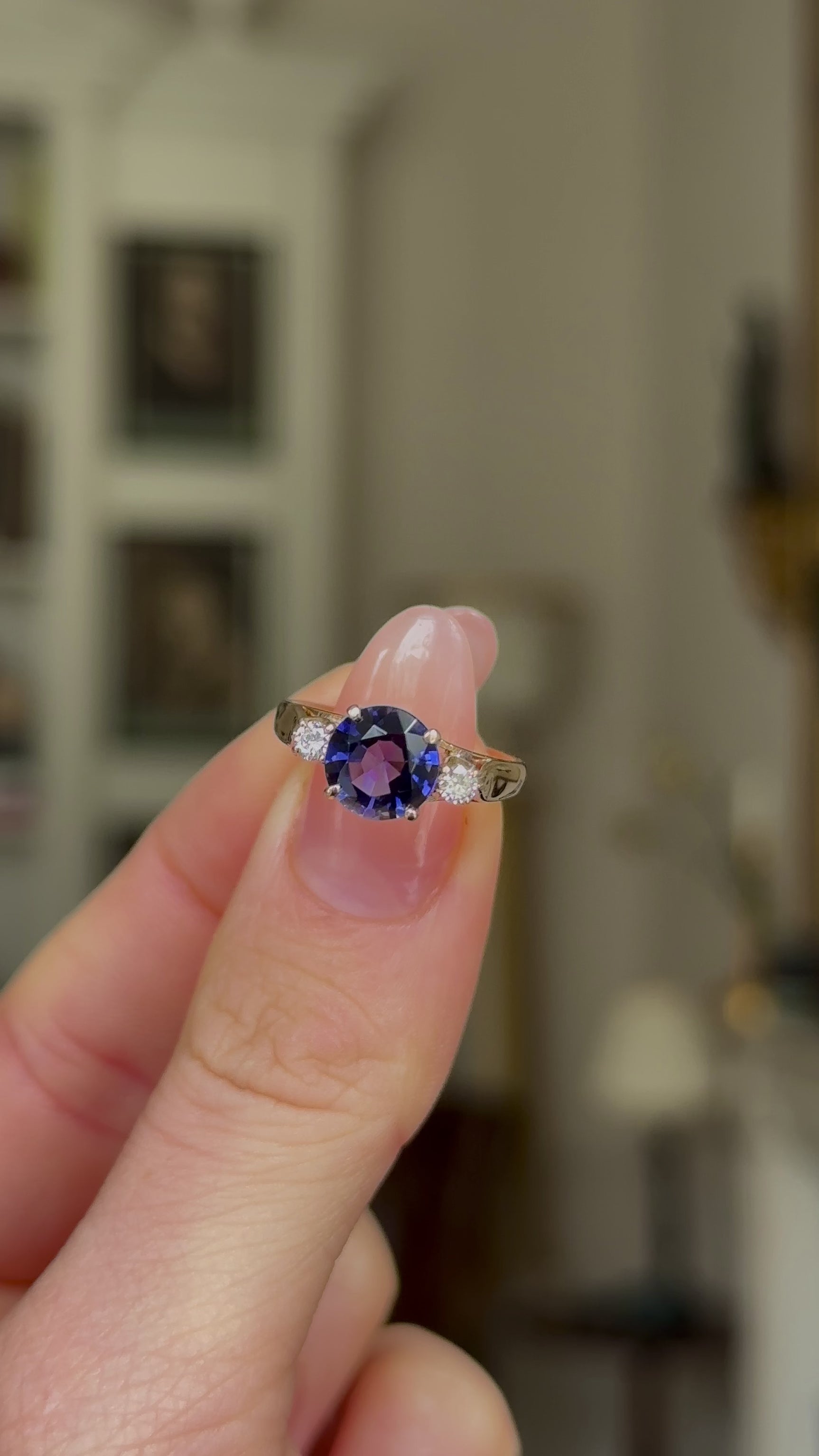Vintage Iolite and Diamond Three-Stone Engagement Ring, 18ct Yellow Gold held in fingers and rotated to give perspective.