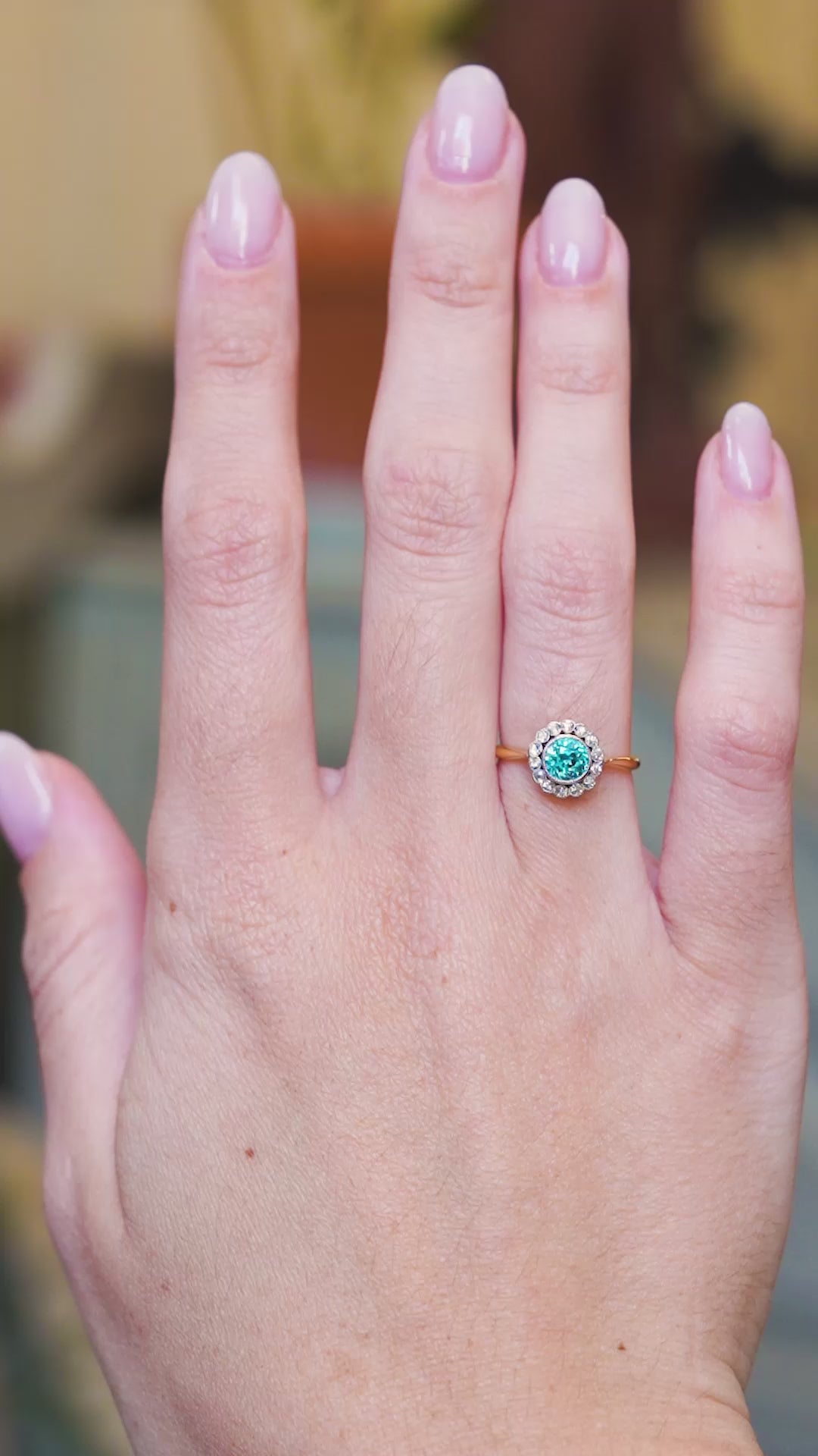 Zircon and diamond cluster ring shown in close detail with bright blue centre stone. 