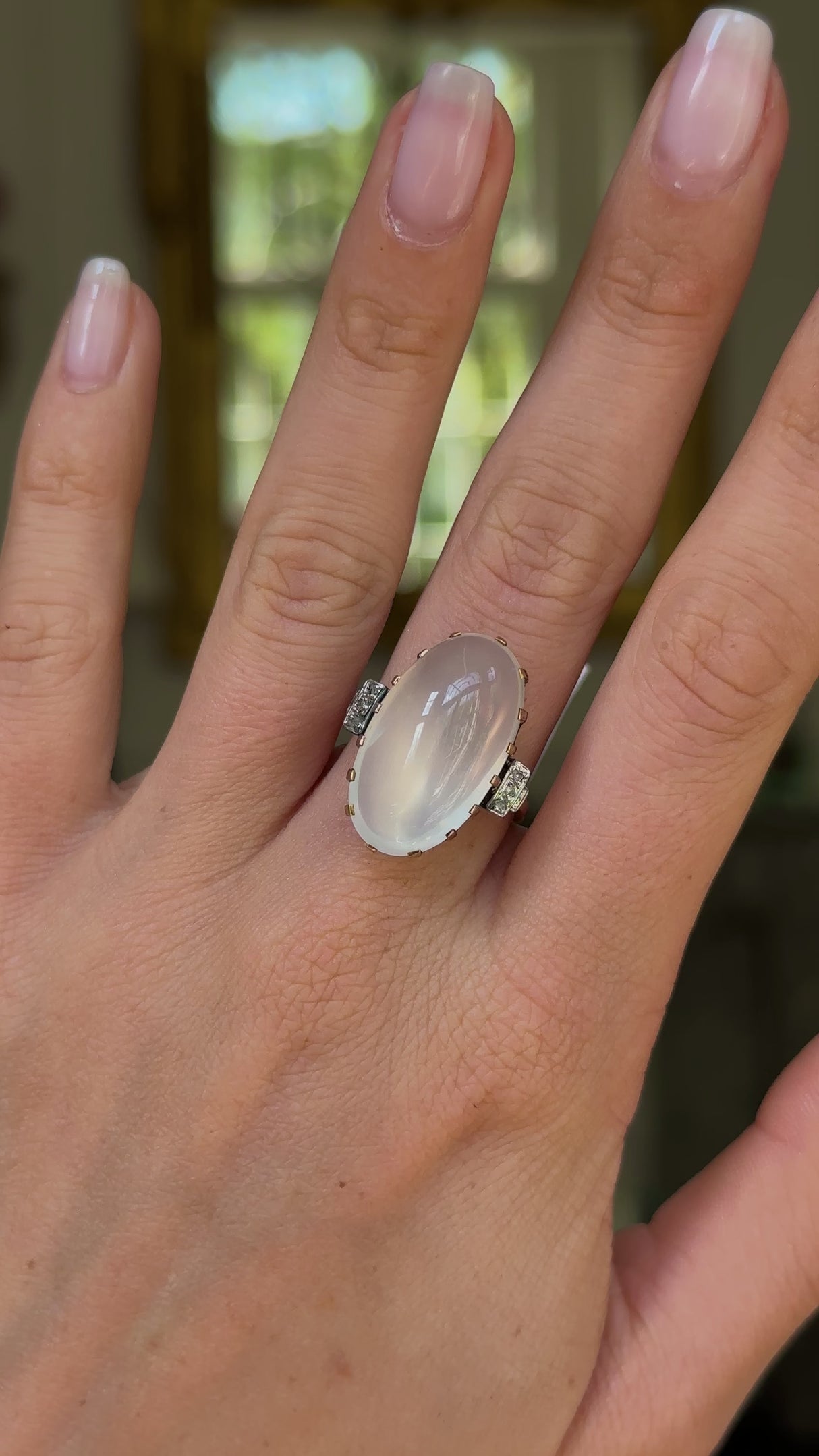 Moonstone and diamond ring, worn on hand and moved around to give perspective.