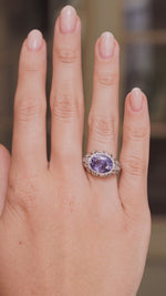 A video of an Antique, Belle Époque Ceylon colour-change sapphire and diamond cluster ring in platinum worn on the hand and outstretched to show scale