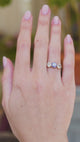 Sapphire and diamond three stone ring worn on hand showing soft lilac blue colour shift in movement.