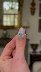 Antique, Edwardian Aquamarine and Diamond Square Cluster Ring, held in fingers and moved around to give perspective.