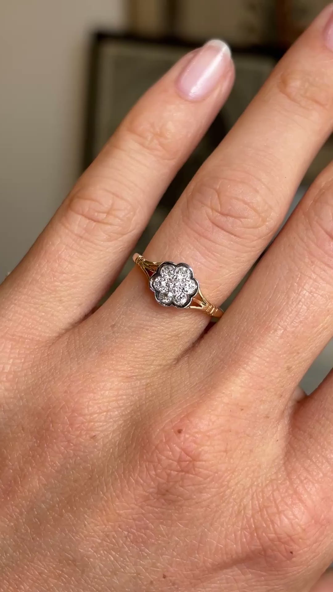 Video of an antique Edwardian old-cut diamond daisy cluster ring worn on hand, showcasing the sparkling old-cut diamond centre and floral-inspired diamond halo.
