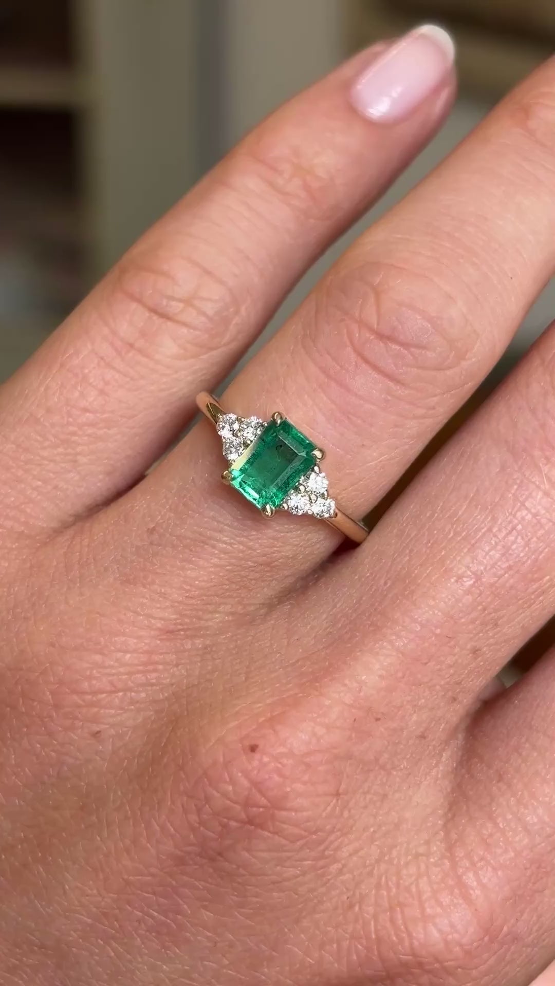 Video of an Antique-inspired, Emerald and diamond trefoil yellow gold engagement ring worn on a finger