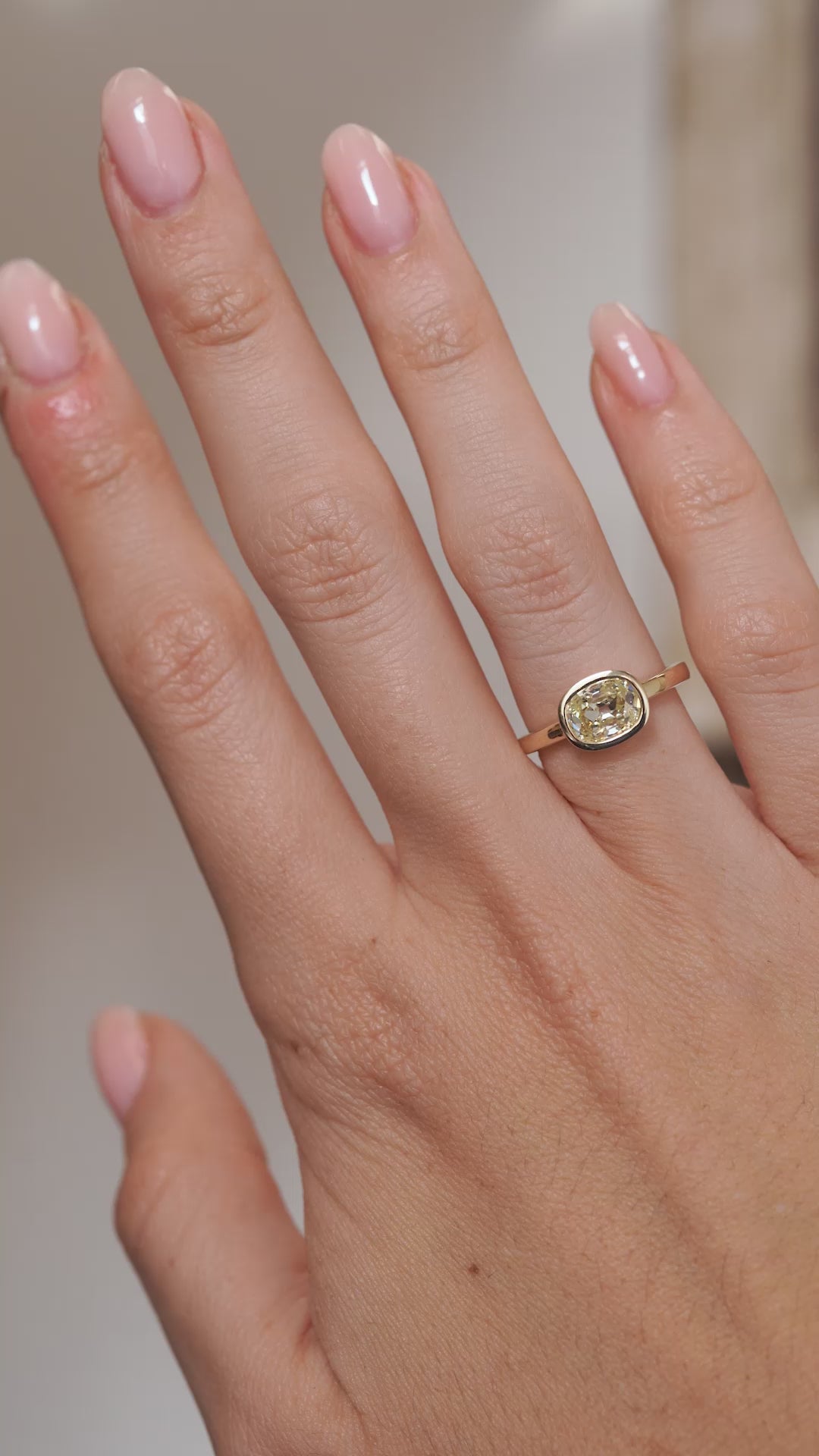 A video of the old mine-cut diamond ring worn on a finger, capturing the gemstone's sparkle and classic yellow gold setting.