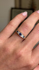 Video of an Antique, Victorian sapphire & diamond five-stone engagement ring in yellow gold worn on a hand against a blurred background.